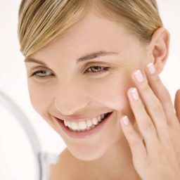woman looking at face in mirror after chemical peel